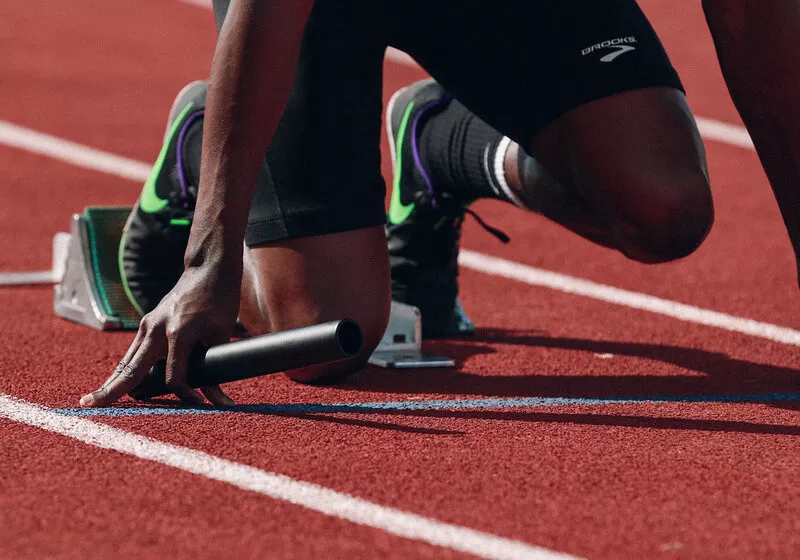 Atleta se preparando para corrida em pista vermelha