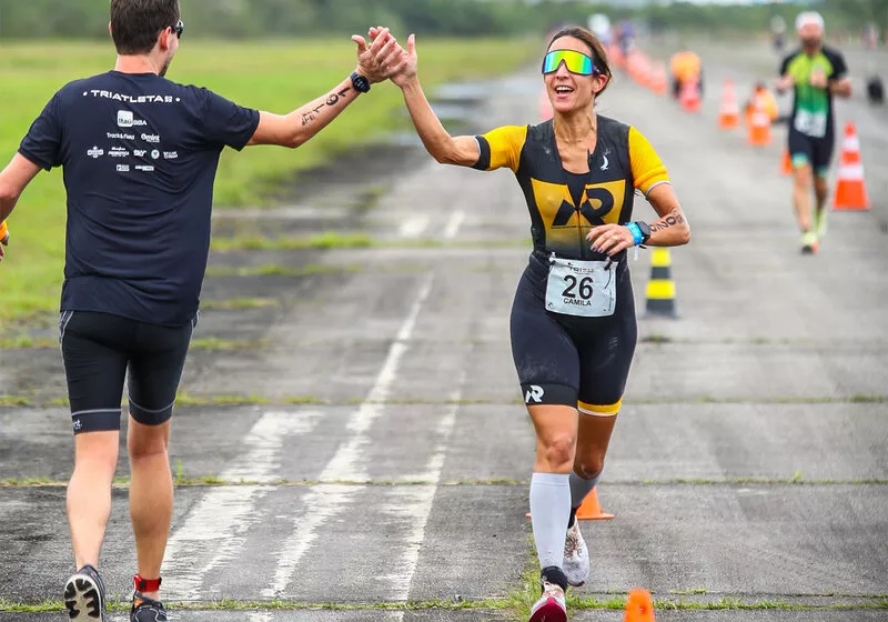 Atleta cumprimenta colega durante corrida de triathlon