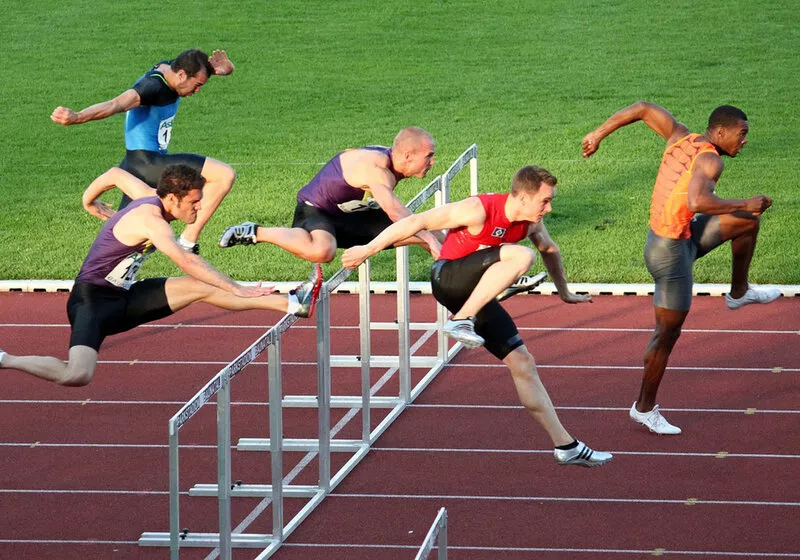 Atletas correndo em uma competição de salto com barreiras