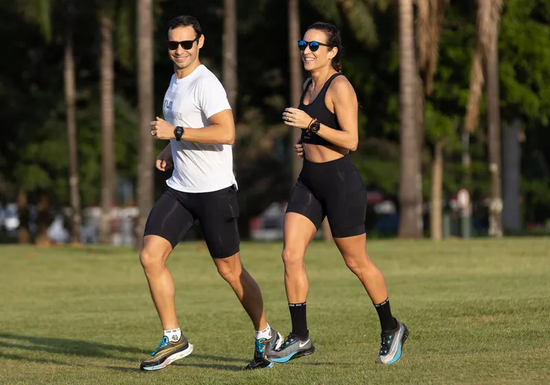 Casal correndo em parque ao ar livre