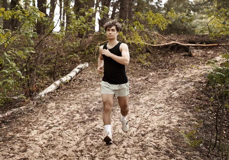 Homem correndo em trilha natural de areia