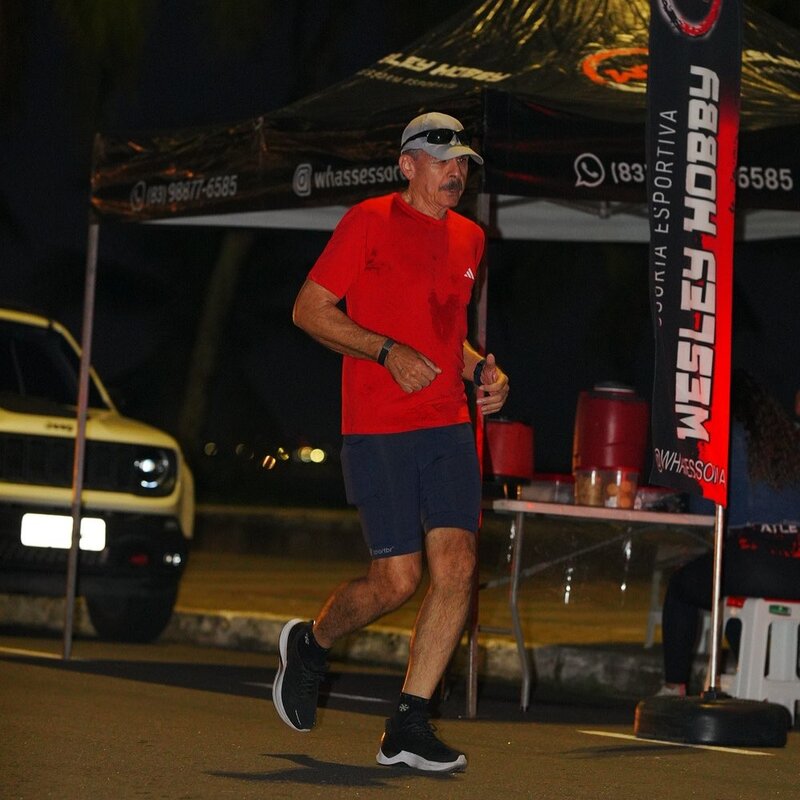 Homem correndo em evento esportivo à noite