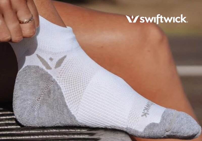 Meia branca da Swiftwick em pé sobre uma superfície