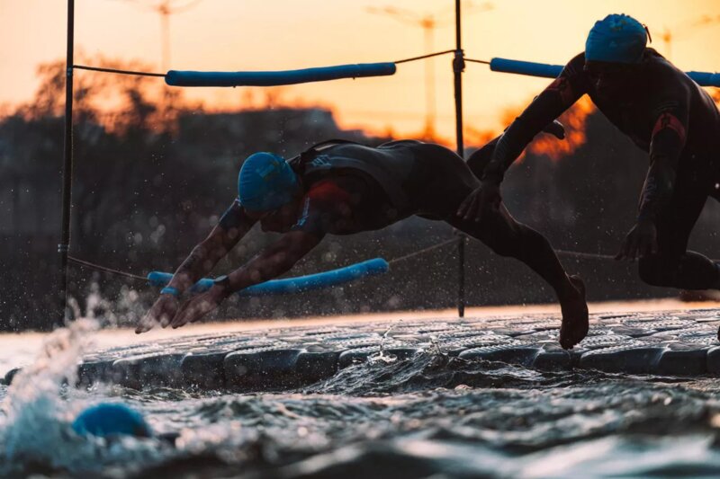 Atleta mergulhando na água ao pôr do sol